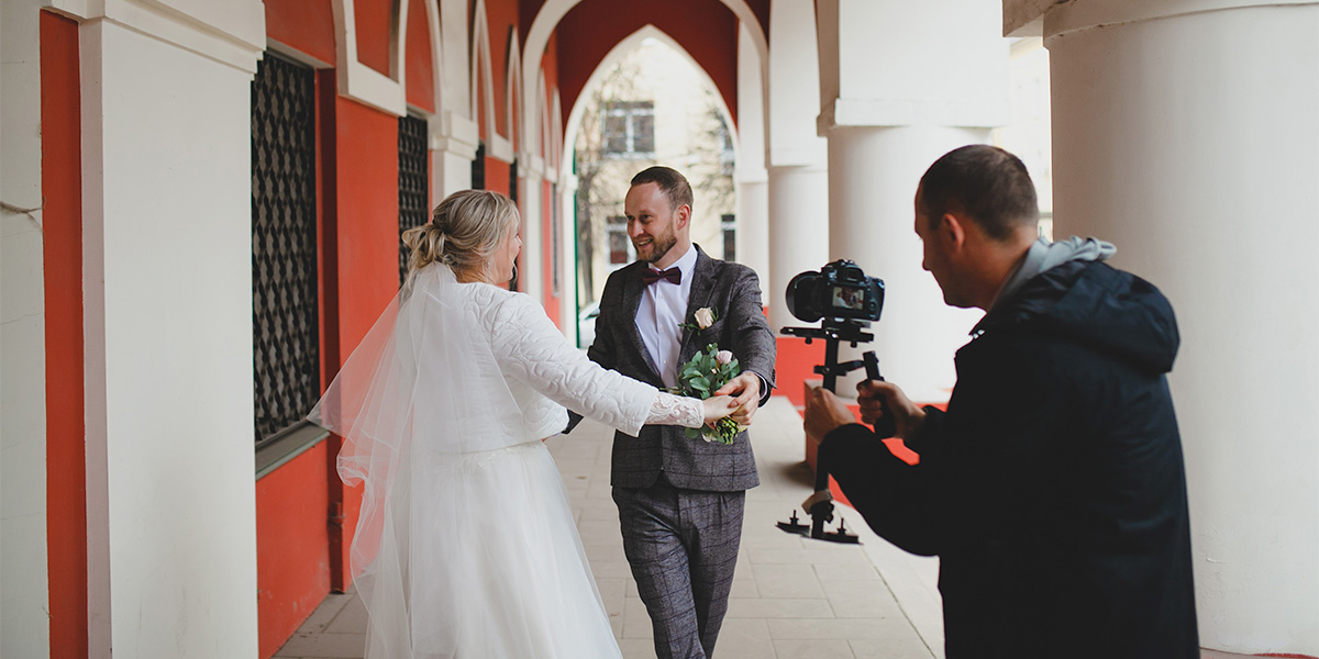 a videographer is taking a video of a bride and groom