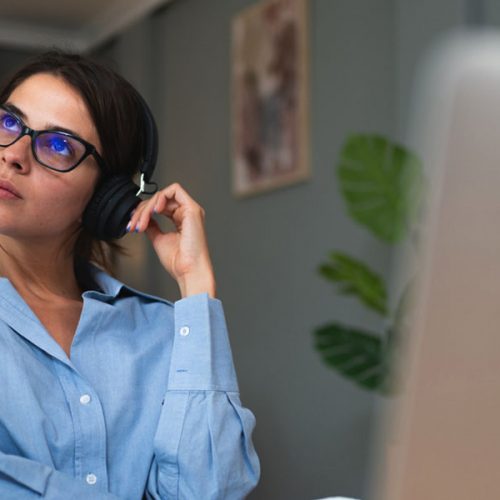 a woman sitting at a desk with headphones on