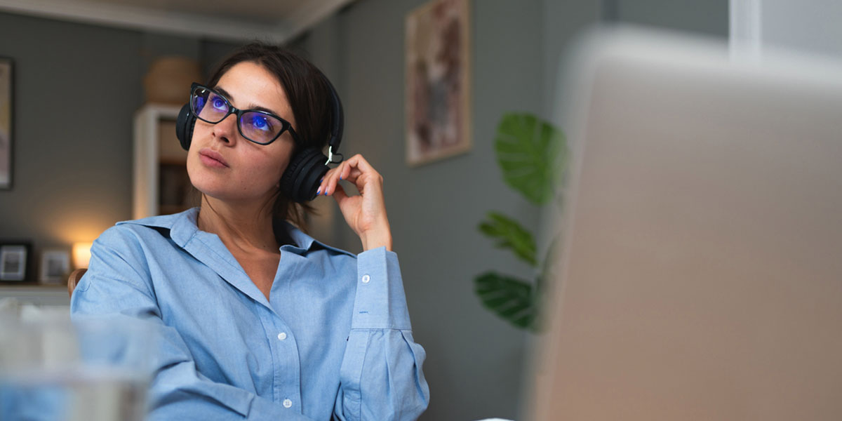 a woman sitting at a desk with headphones on